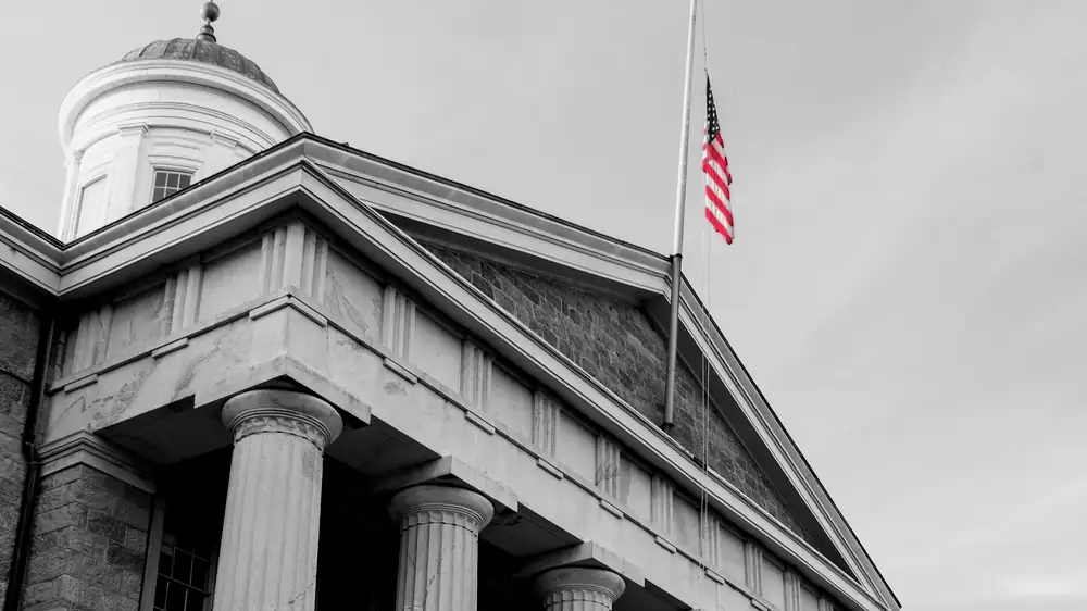 A columned government building with an American flag, representing the public services agencies keep running