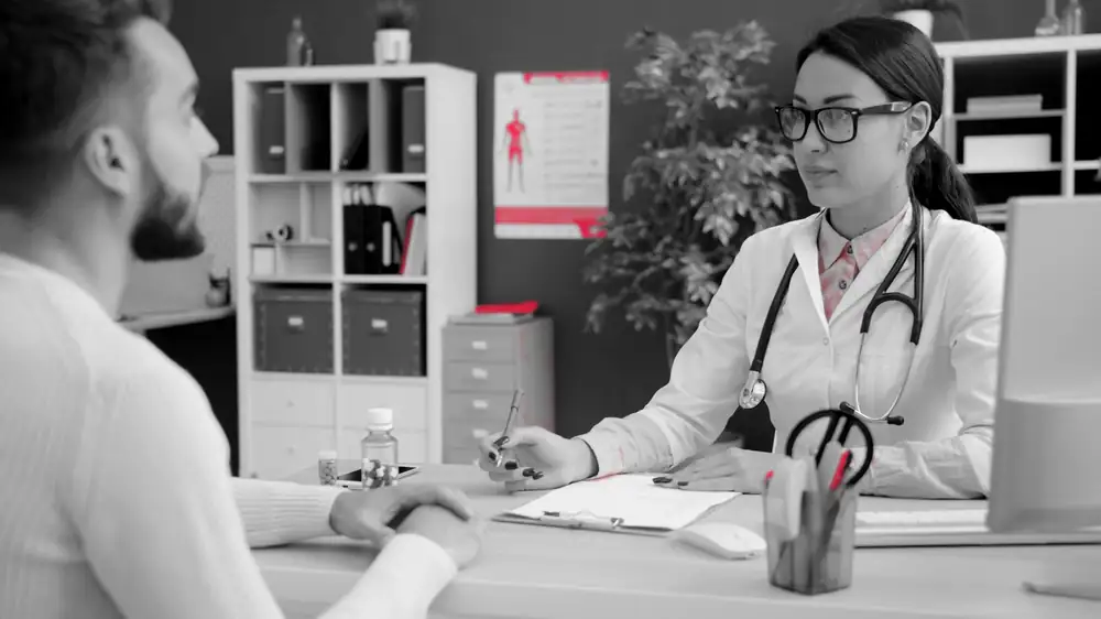 A doctor reviewing notes with a patient in a clinic office, where protected health information is created every day