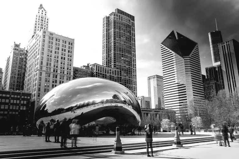 The Cloud Gate sculpture in Millennium Park with the Chicago skyline behind it