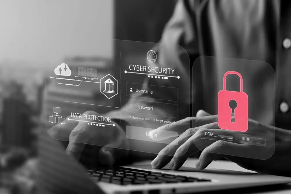 Hands typing on a laptop behind a translucent login screen and padlock, the defenses a cybersecurity audit puts to the test