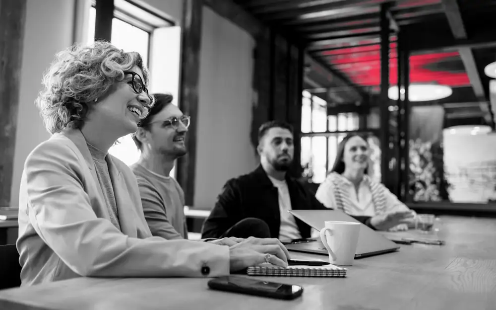A leadership team around a conference table reviewing results, the audience a NIST CSF maturity score is written for