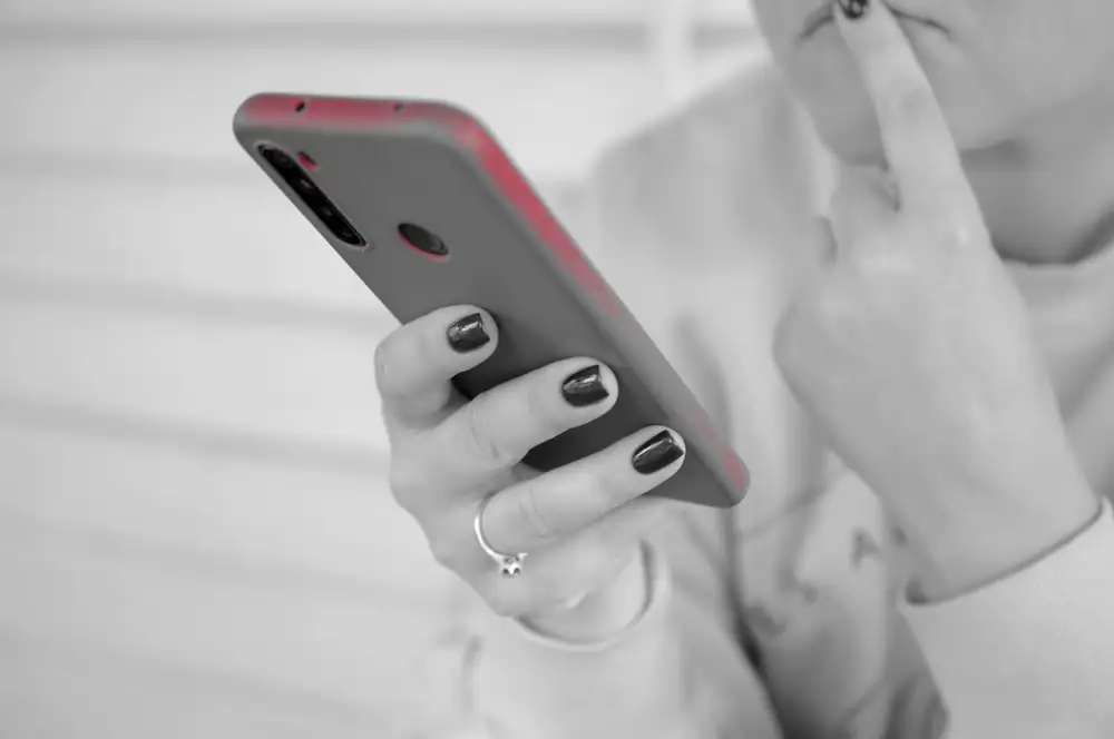 A person looking at their phone, the kind of everyday moment where personal information is collected and shared