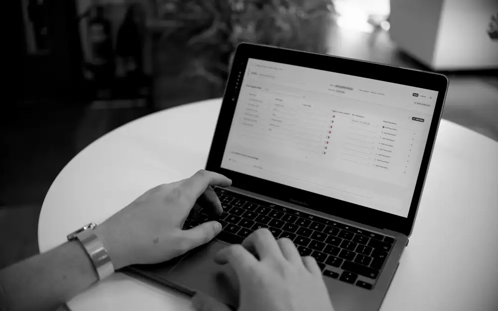 Hands typing on a laptop with a spreadsheet open, the kind of security questionnaire customers send vendors