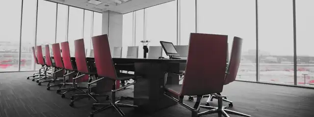 An empty boardroom with a long conference table