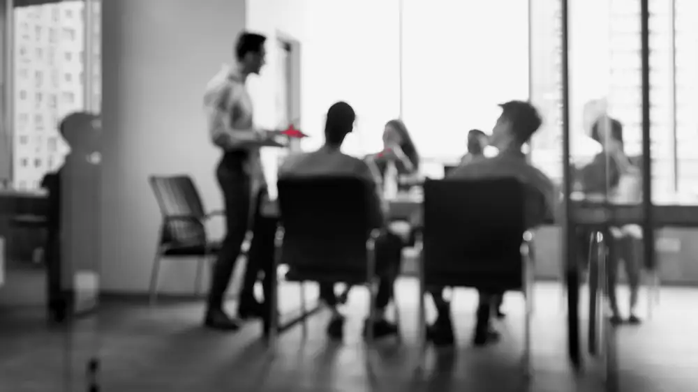 A security leader briefing an executive team around a conference table